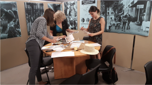 Three women around a table cutting out images
